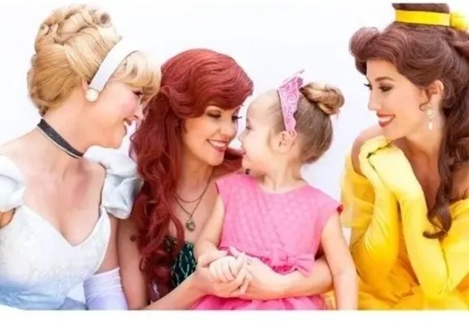 Three princesses greeting a little girl