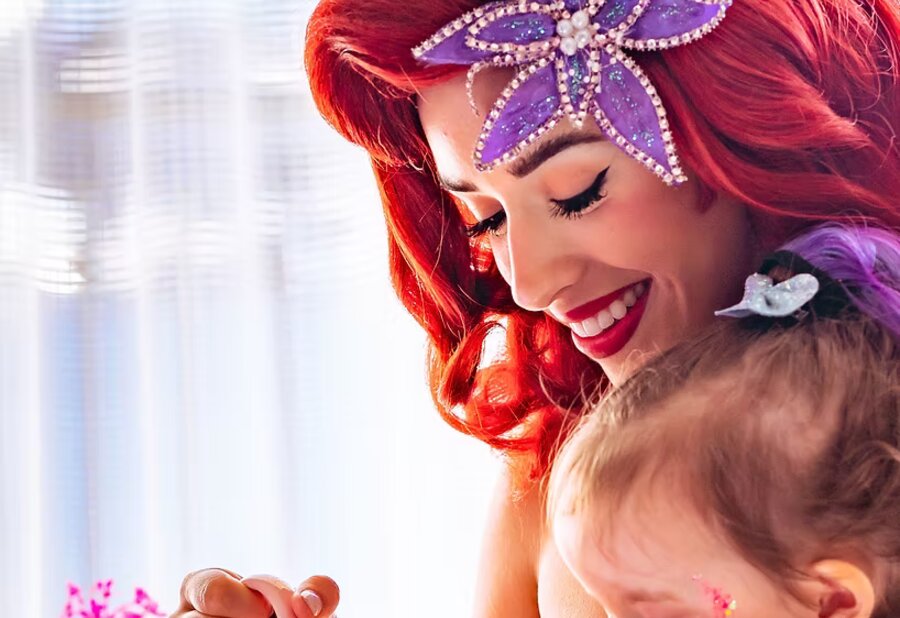 Two mermaid characters at a celebrity first birthday, featured in People
