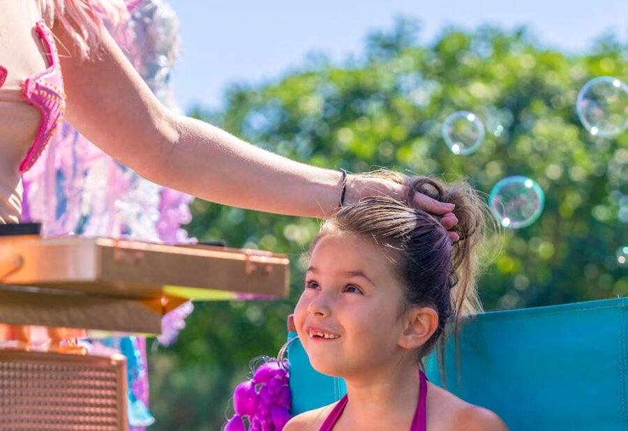 A mermaid stylist creating an updo at the traveling salon